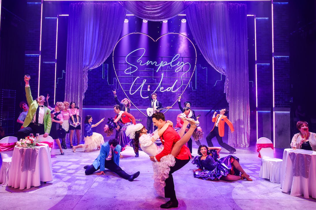 performers dressed in bright 80s-inspired costumes on stage